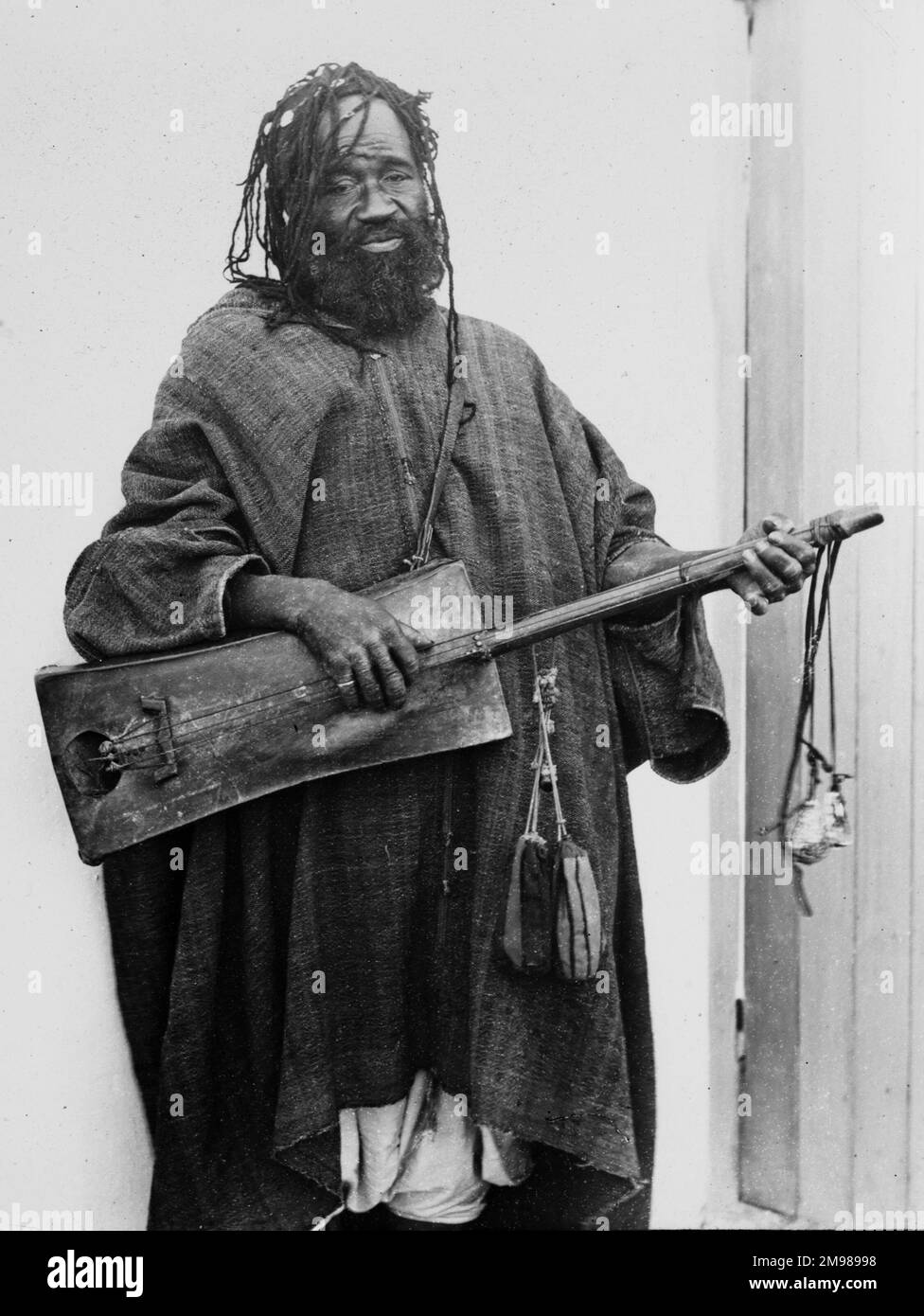Ein alter maurischer Musiker, der ein Saiteninstrument spielt, vielleicht ein Gimbri. Stockfoto