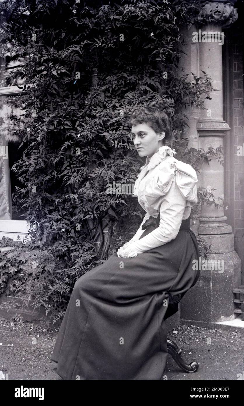 Eine Frau, die vor einem Haus sitzt. Stockfoto