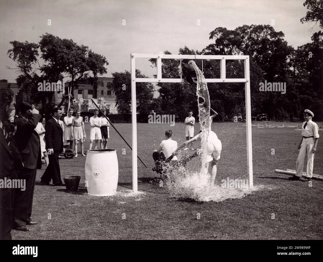Marinetätigkeiten auf einem Sportplatz mit einem Eimer Wasser. Stockfoto