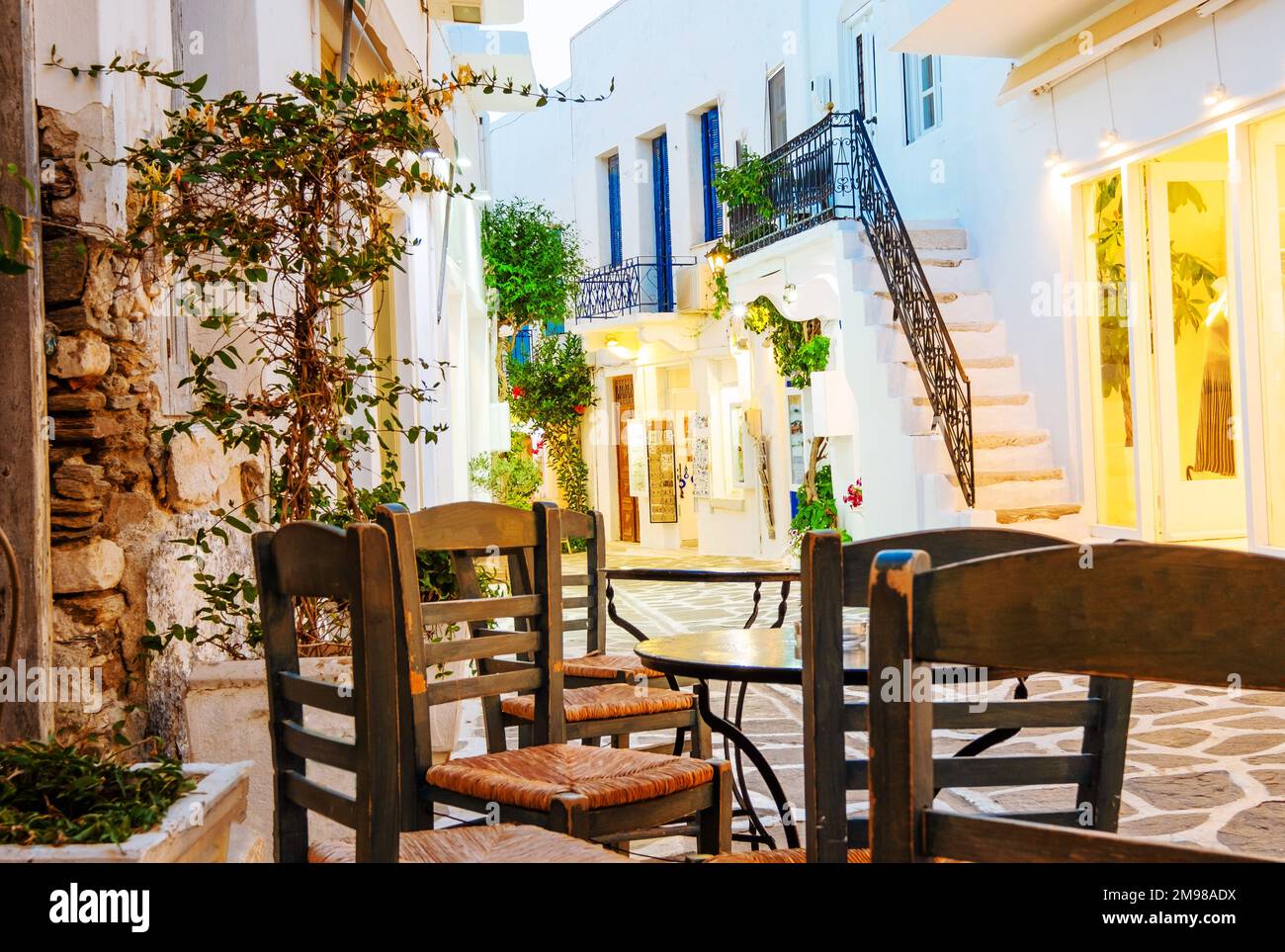 Vergrößerung von Holzstühlen und -Tischen im Hintergrund der griechischen Straße Stockfoto