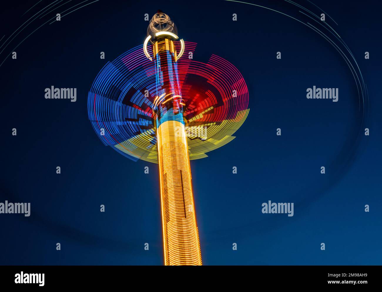 Abstrakte bunte Spuren von Karussell vor dem dunklen Himmel Stockfoto