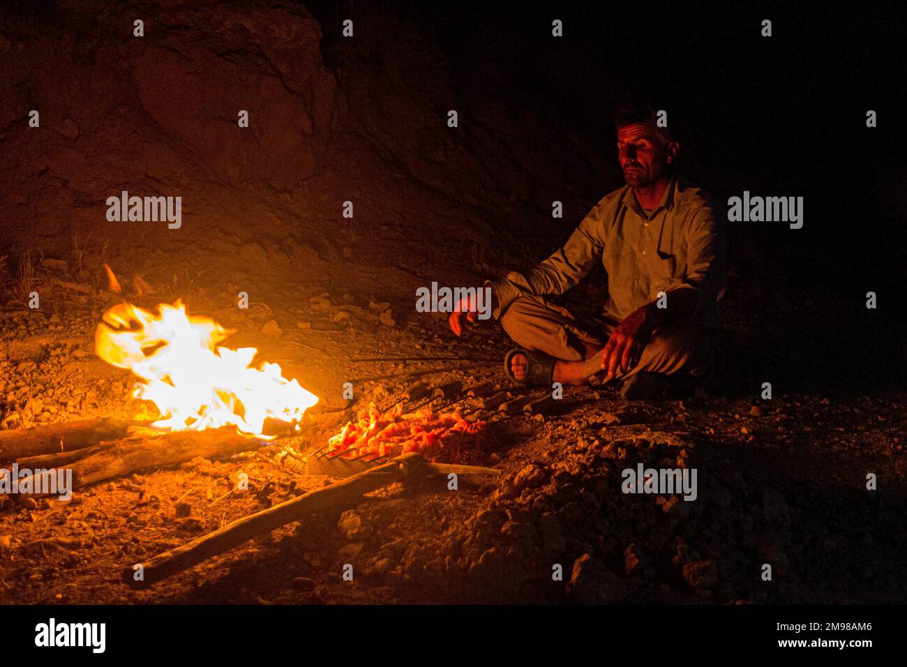 ZAGROS, IRAN - 7. JULI 2019: Nomad veranstaltet Hühnchen-Barbecue in den Zagros-Bergen, Iran Stockfoto