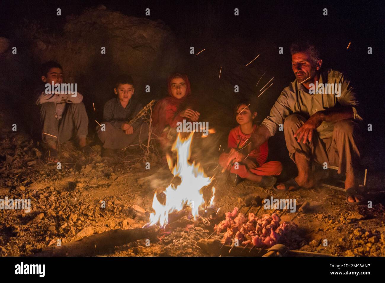 ZAGROS, IRAN - 7. JULI 2019: Familie Nomad bereitet Hühnchen-Barbecue in den Zagros-Bergen, Iran zu Stockfoto