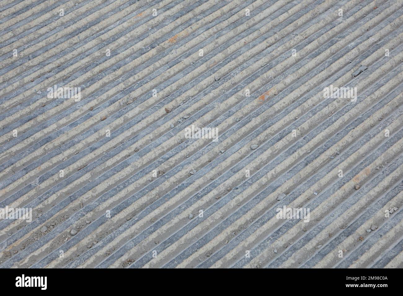 Hintergrund mit grauer Zementoberfläche und Kanälen für Wasserdurchfluss. Stockfoto