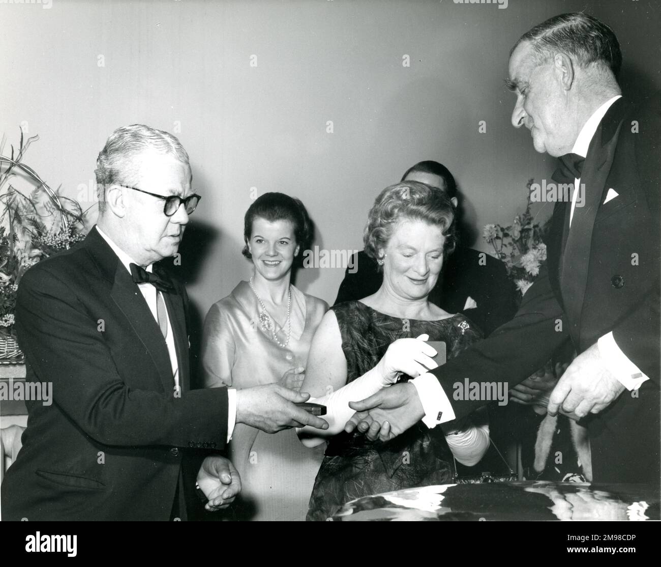 Dr. Archie ballantyne, Sekretärin von Raes, rechts, präsentiert Sir George Gardner, Präsident von Raes, Links, mit goldenen Manschettenknöpfen, die das Turmfalz der Gesellschaft tragen, und Lady Gardner mit einer goldenen Brosche in Form des hundertjährigen Symbols auf dem Centenary Conversazione, der am 12. Januar 1966 im Science Museum stattfand. Stockfoto