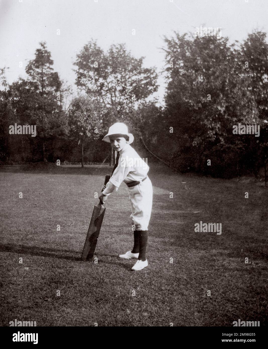 Der kleine Junge (Harold Auerbach) übt Cricket in seinem Garten in Ealing, West London. Er trägt seine Durston House School Sportuniform. Stockfoto
