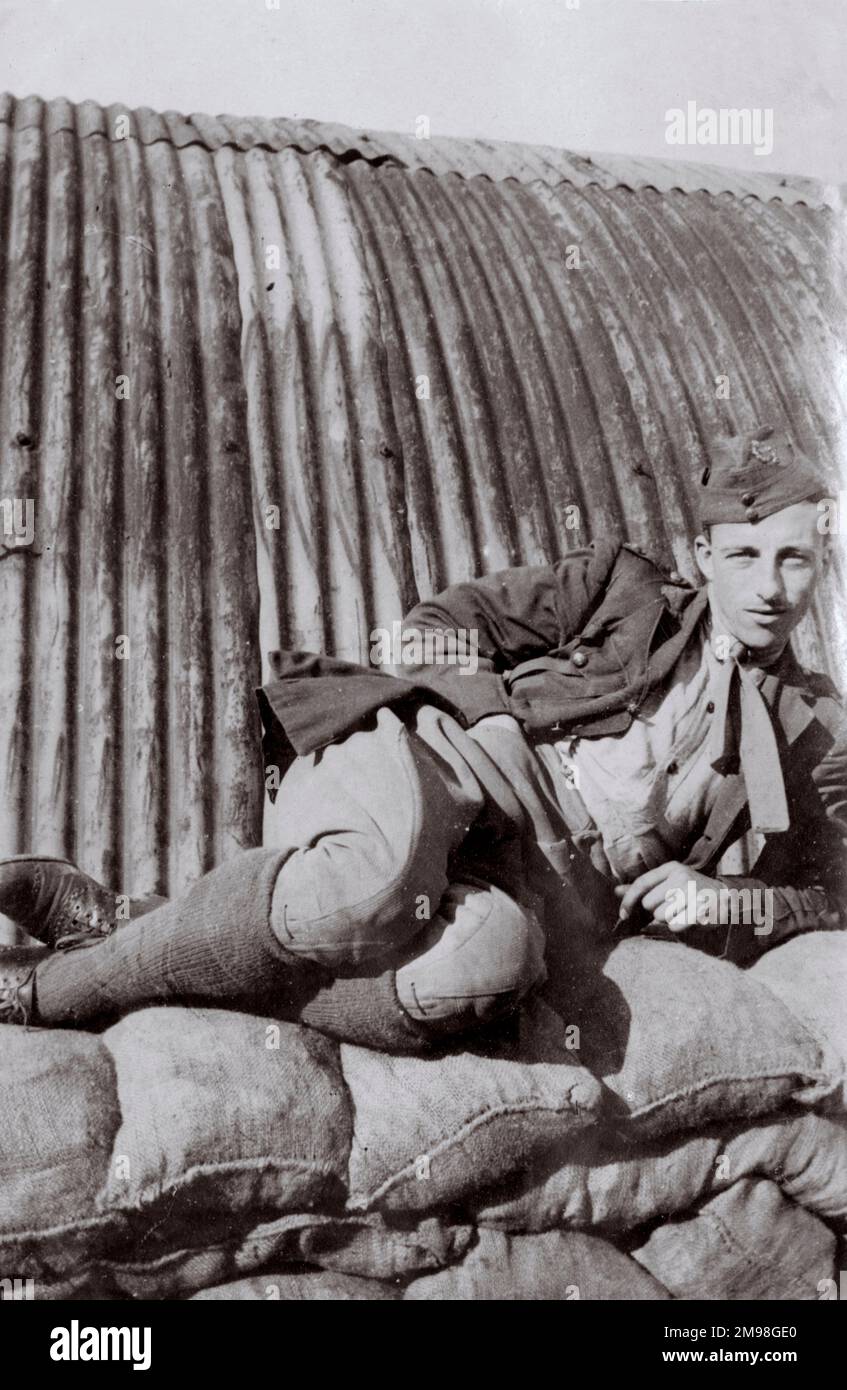 Die Crew des Royal Flying Corps entspannt sich auf einem Haufen Säcke vor einer Welleisenhütte, irgendwo in Nordfrankreich während des Ersten Weltkriegs. Stockfoto