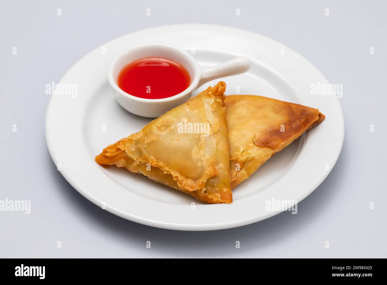 Zwei Samosas mit Fleisch und Gemüse auf weißem Teller Stockfoto