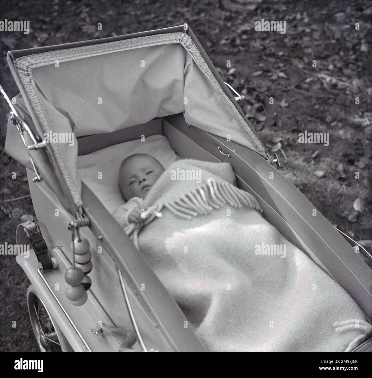 1950er historisch, ein Baby, das auf dem Rcken unter einer Decke in einem  Kinderwagen oder Kinderwagen liegt, England, Grobritannien Stockfotografie  - Alamy