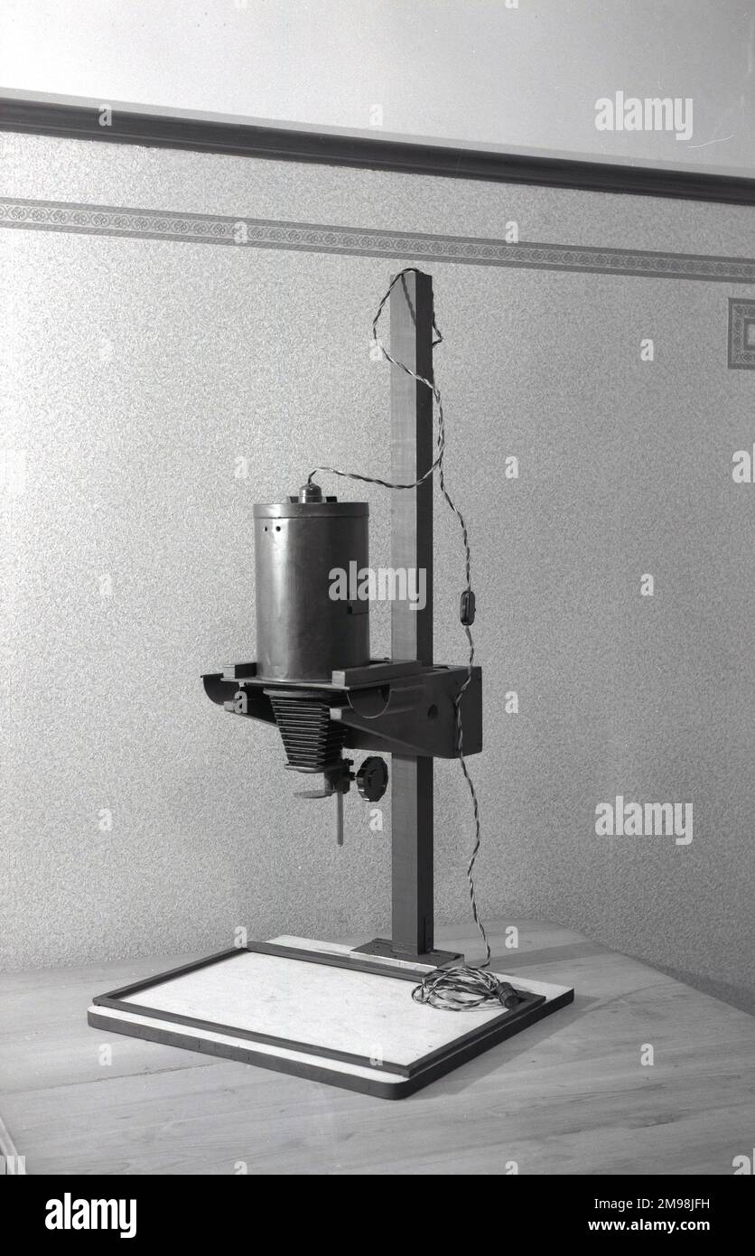 1950er, historisch, eine Fotovergrößerung der Ära, auf einem Ständer, mit Fuß, Kabel und Stecker, auf einem Tisch. Diese Fotoausrüstung hatte eine Linse und wurde in einem dunklen Raum verwendet, um größere Ausdrucke von kleineren Originalfilmnegativen zu erstellen. Stockfoto