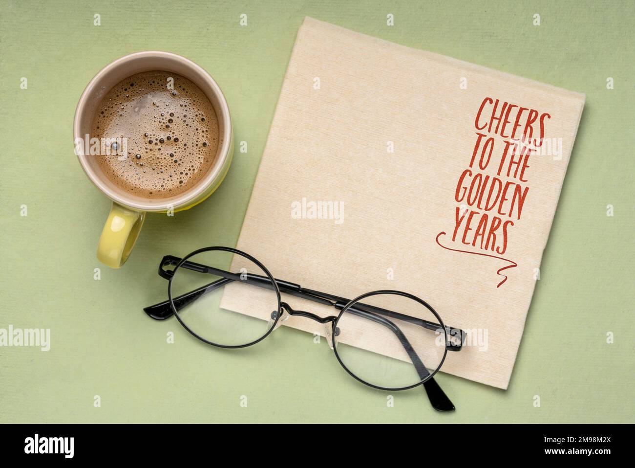 Prost auf die goldenen Jahre - fröhliche Nachricht auf einer Serviette mit Kopierbereich, Altersvorsorge Stockfoto