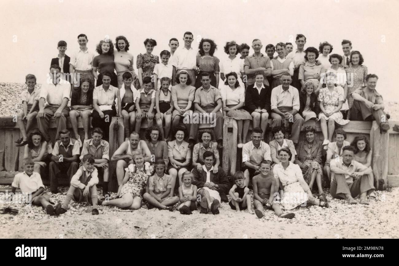Große Gruppe am Strand („New Beach“) - ein „Pfeiffoto“ mit vielen Menschen (die einander unbekannt sind), die sich versammelt haben, um von der Pfeife eines Fotografen fotografiert zu werden! Stockfoto