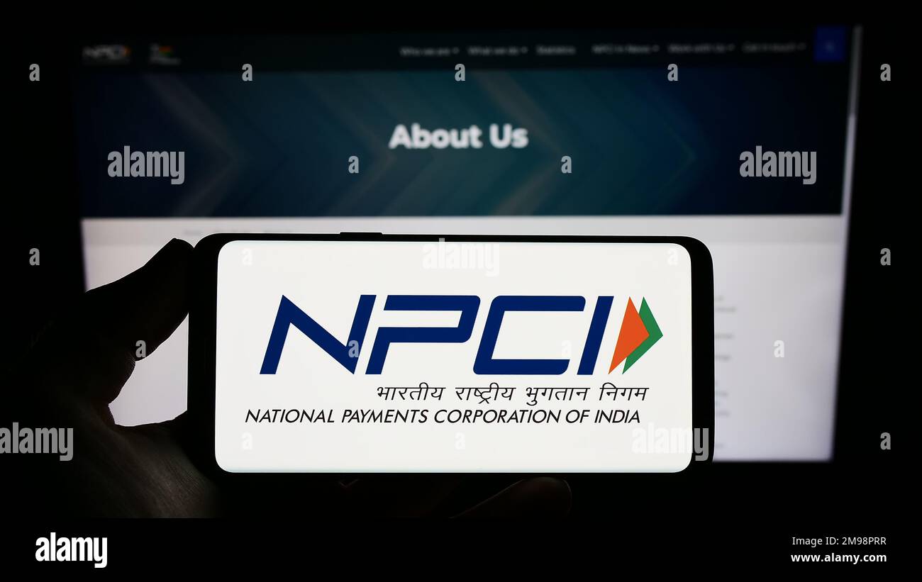 Person, die ein Smartphone mit dem Logo der National Payments Corporation of India (NPCI) auf dem Bildschirm vor der Website hält. Konzentrieren Sie sich auf das Display des Telefons. Stockfoto