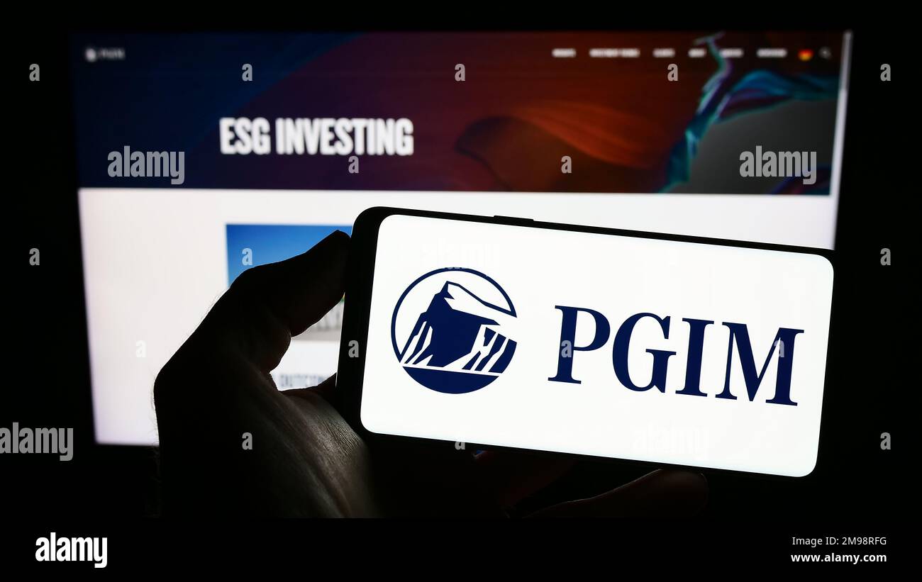 Person, die ein Mobiltelefon mit dem Logo der amerikanischen Vermögensverwaltungsgesellschaft PGIM Inc. Auf dem Bildschirm vor der Webseite hält. Konzentrieren Sie sich auf das Display des Telefons. Stockfoto