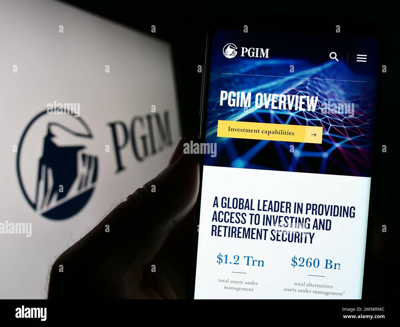 Person, die ein Mobiltelefon mit einer Website der US-amerikanischen Vermögensverwaltungsgesellschaft PGIM Inc. Auf dem Bildschirm vor dem Logo hält. Konzentrieren Sie sich auf die Mitte des Telefondisplays. Stockfoto