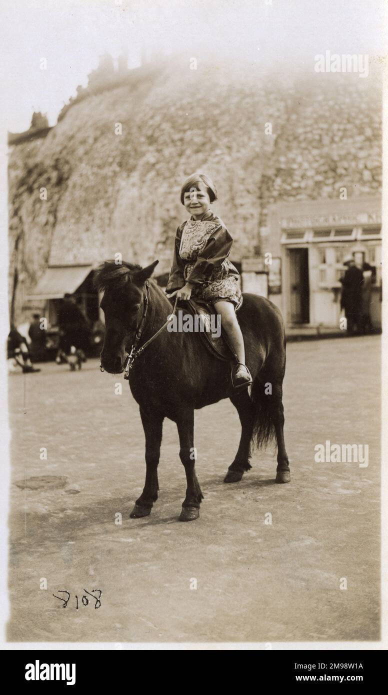 Junges Mädchen auf einem Pony - Britisches Strandfoto - Margate, Kent. Das Büro des Fotografen kann man hinten rechts sehen. Stockfoto