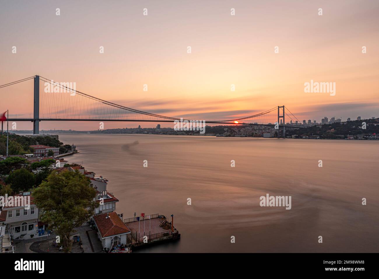 Istanbul Bosporus-Brücke bei Sonnenuntergang. 15. Juli Martyrs Bridge. Blick auf den Sonnenuntergang von Beylerbeyi. Istanbul, Türkei Long Exposure. Stockfoto