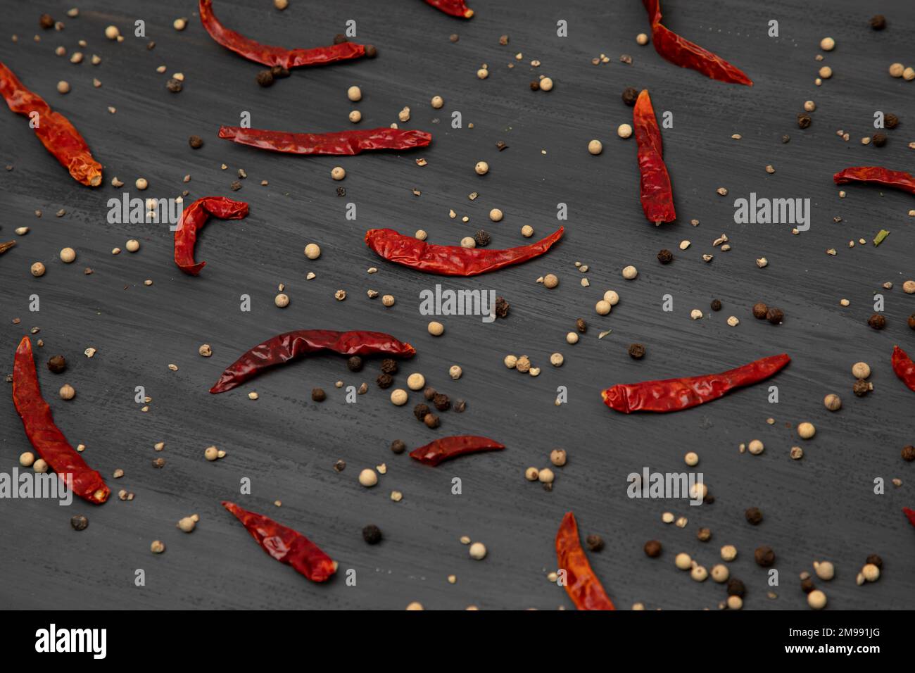 Muster getrockneter roter Chili-Paprika mit Gewürzen wie Pfeffer auf grauem Hintergrund Stockfoto