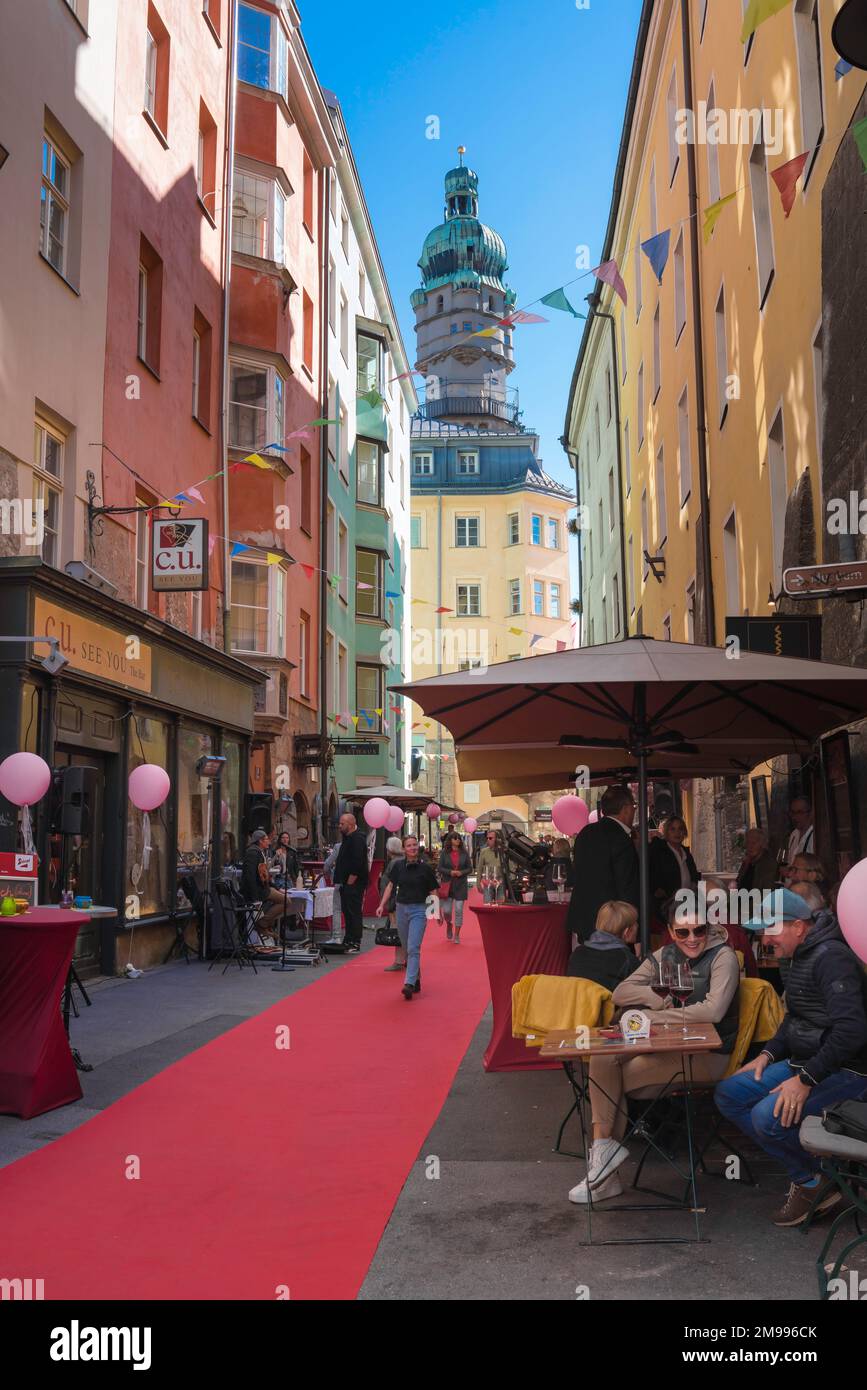 Innsbrucker Café-Bar-Straße, Blick auf die Menschen, die sich an den Cafétischen in der Pfarrgasse in der historischen Altstadt von Innsbruck entspannen Stockfoto