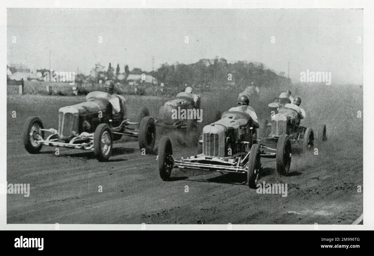 Eine Gruppe von Autos auf halber Strecke auf der Eröffnungsrunde eines amerikanischen Dirt-Track-Events. Stockfoto