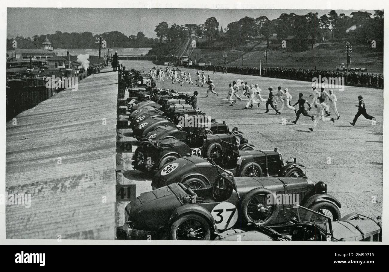 Beginn eines Brooklands Double-Twelve-Rennens mit Fahrern und Mechanikern, die zu ihren Maschinen Rennen. Stockfoto