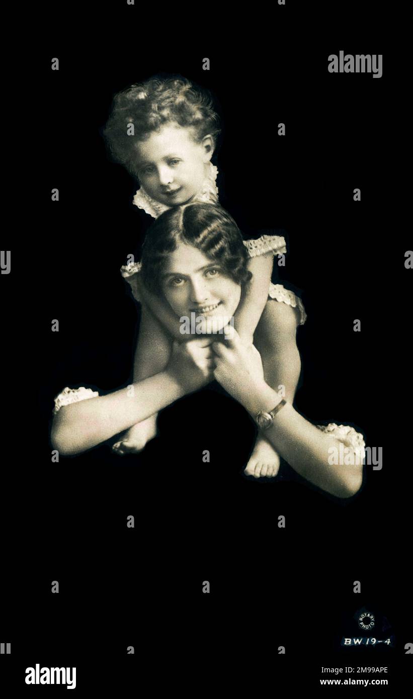 Fröhliche, lächelnde Mutter mit ihrem Sohn, der auf ihren Schultern getragen wurde. Stockfoto