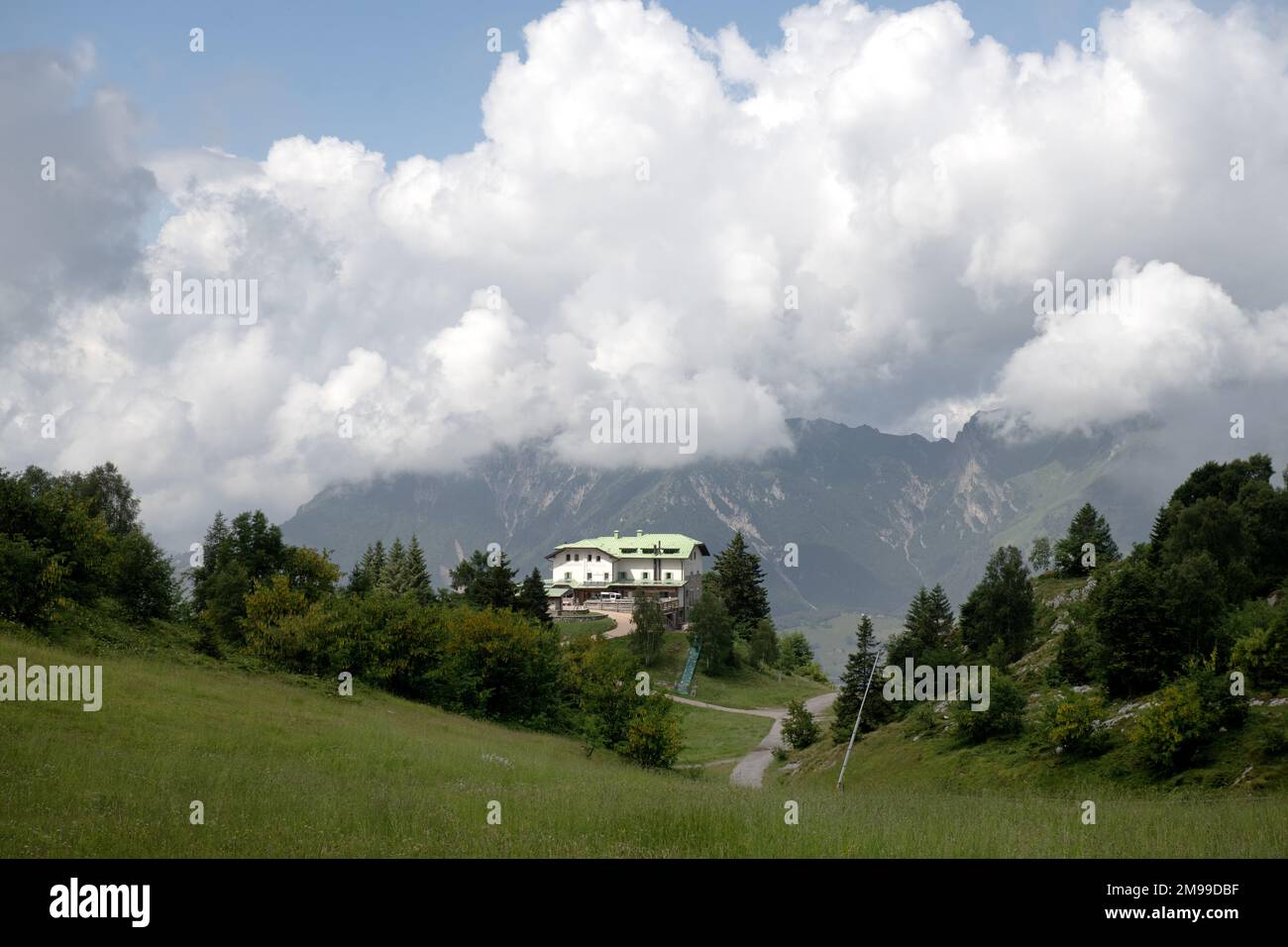 Berghütte umgeben von weißen Wolken auf den Alpen rund um den Comer See Stockfoto