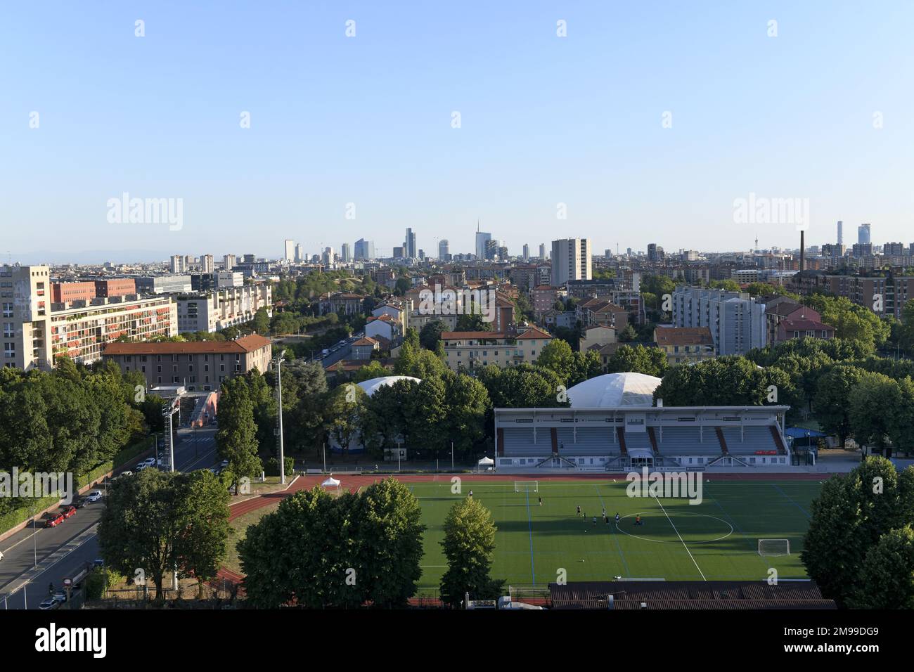 Blick von oben auf das Fußballstadion eines Vororts mit der Skyline von Mailand im Hintergrund Stockfoto