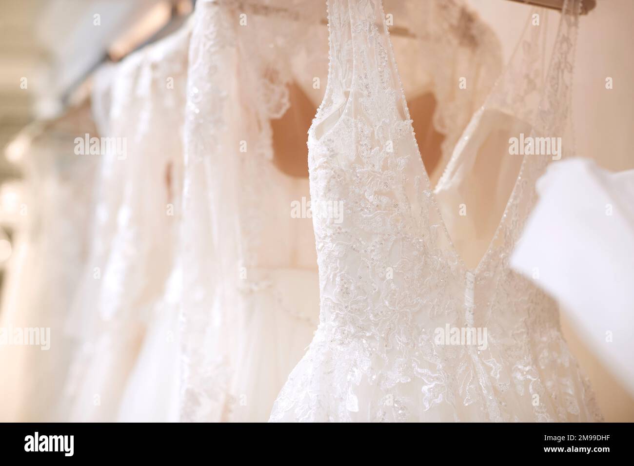 Nahaufnahme Der Wunderschönen Hochzeitskleider, Die Im Laden An Der Schiene Hängen Stockfoto