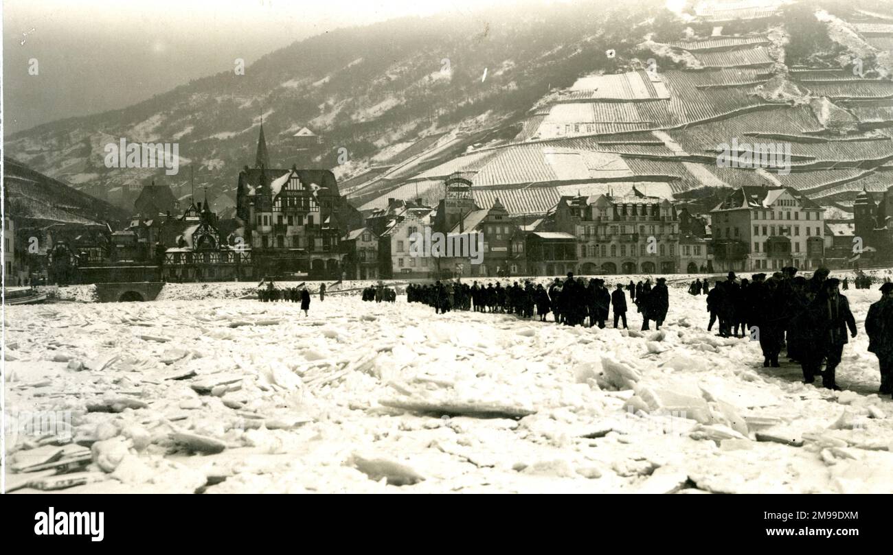 Britische Truppen überquerten den gefrorenen Rhein in Deutschland, mit Weinbergen in der Ferne, nach dem Ende des Ersten Weltkriegs. Stockfoto