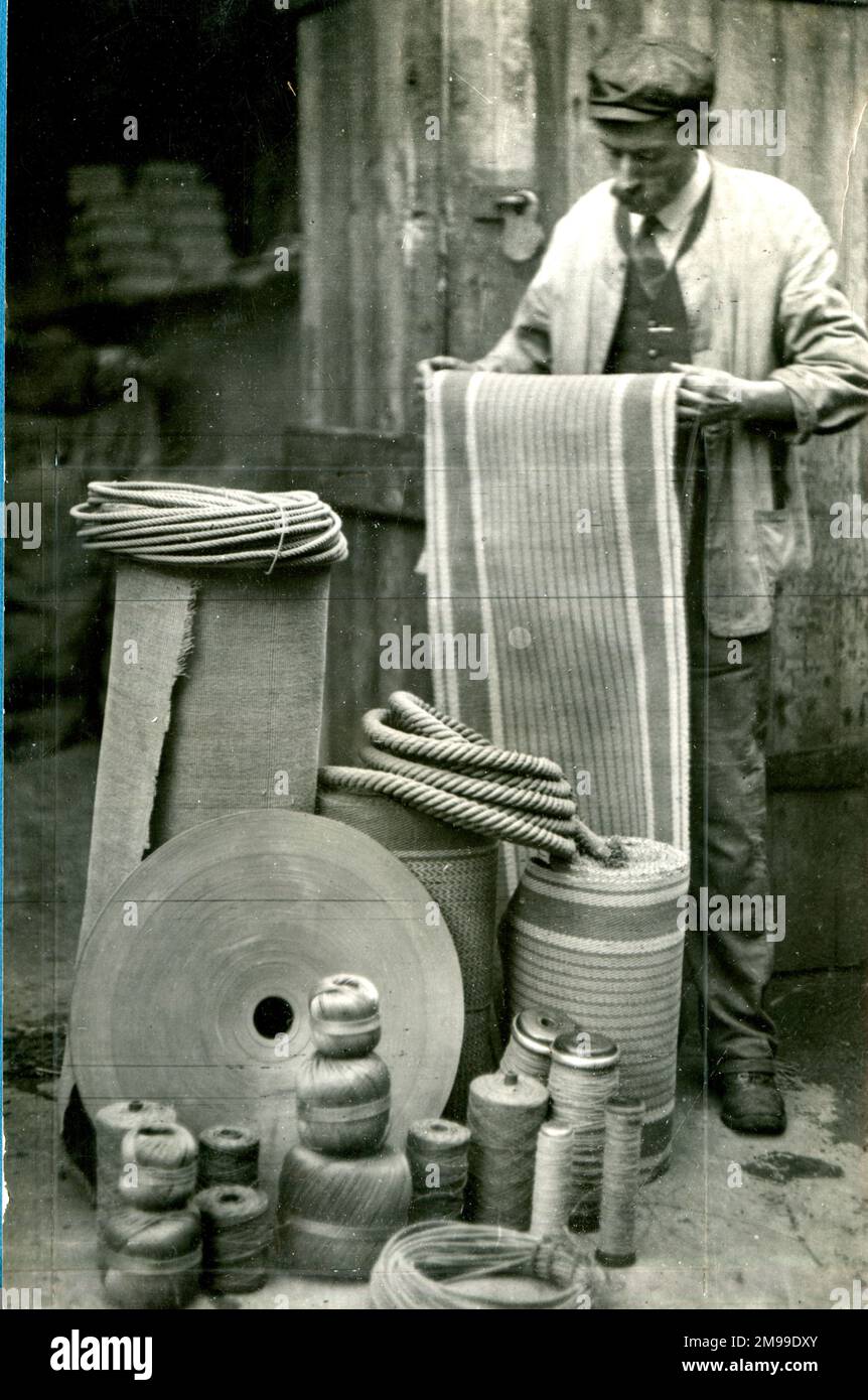 Materialmangel im Ersten Weltkrieg - ein Mann mit Seil, Schnur und Papierrollen. Stockfoto
