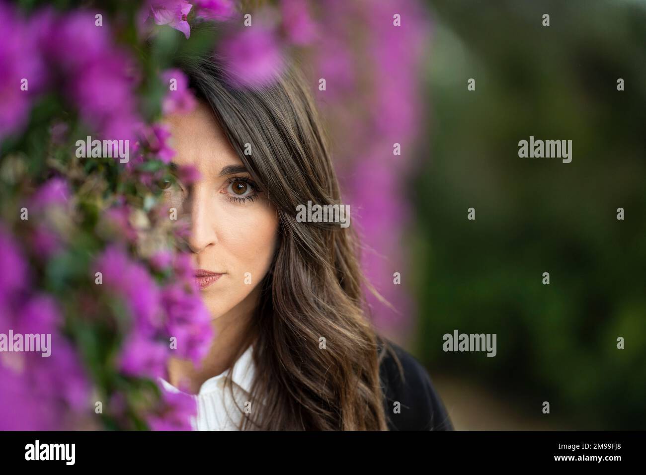 Porträt einer traurigen Frau in der Nähe von violetten Blumen Stockfoto
