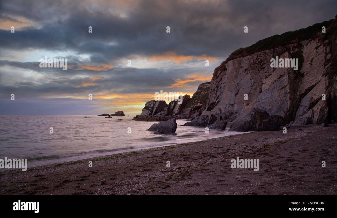 Ein Bild der wunderschönen Ayrmer Rocks bei Sonnenuntergang in South Devon, England, Großbritannien. Stockfoto