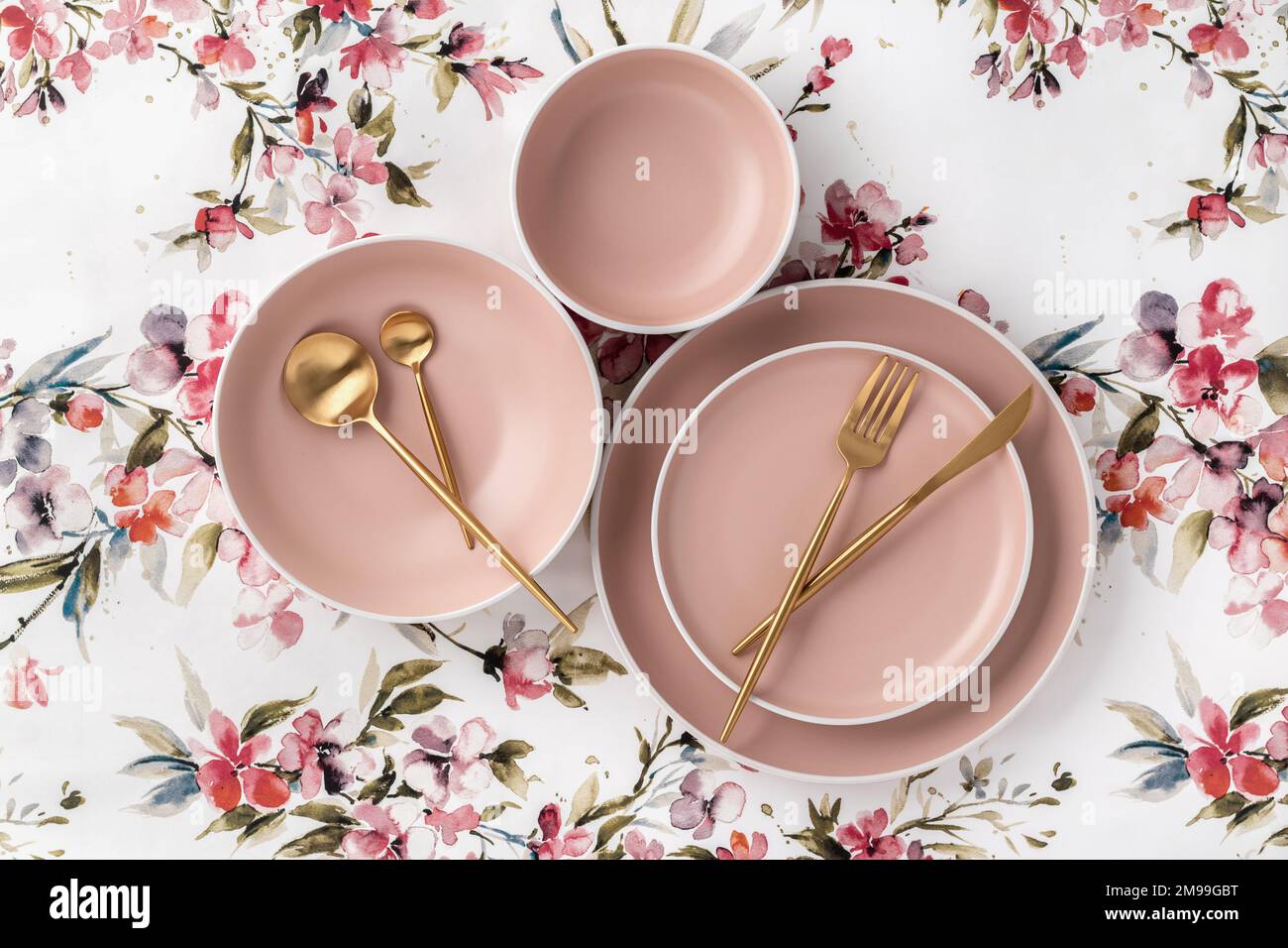 Geschirr und Besteck auf einer weißen Tischdecke mit Blumenmuster, Blick von oben auf den Tisch. Flach liegendes Design. Leere Keramikteller, Utensilien zum Servieren. Tr Stockfoto