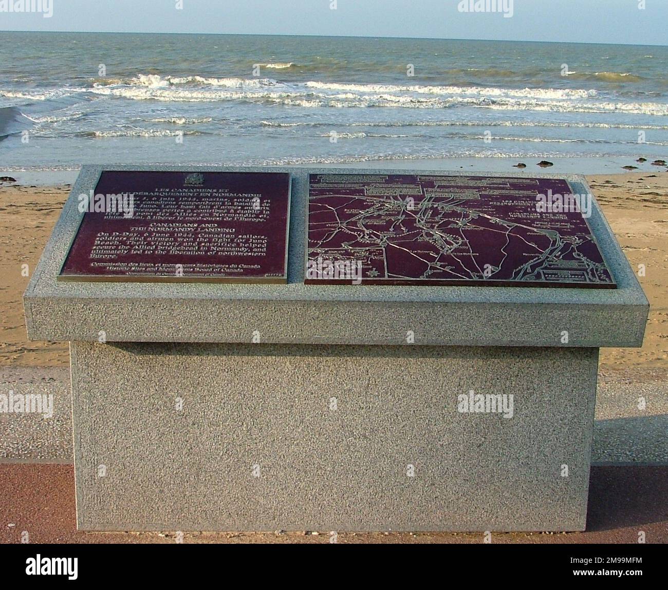 Metallplaketten in der Nähe des Meeres werden unweigerlich durch die Salzluft korrodiert. Die in diesem Steinpfeiler, am Strandeingang, sind da keine Ausnahme. Die oberste Plakette ist für das 1. Kanadische schottische Regiment, das nächste für „belgische Freiwillige“ und andere für 8. Mrd. Royal Scots, die 6. Mrd. Royal Scots Fusiliers und 6. KOSB. Stockfoto