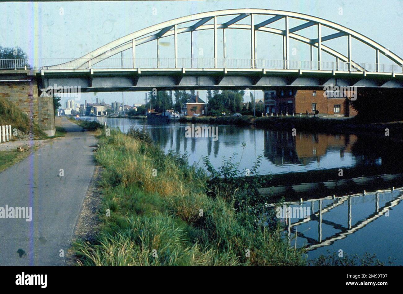 Operation Market Garden war ein britisch-amerikanischer Land- und Flugbetrieb, der in und um die deutsche Verteidigung einbrechen und dann nach Deutschland selbst weiterfliegen wollte. Die Landstreitkräfte, vor allem hier die Panzer der irischen Garde, warteten am 17. September 1944 darauf, dass die Luftstreitkräfte überfliegen und den Weg frei machen. Unter der Brücke befindet sich eine Gedenkstätte für ihre Ergreifung durch die Wachen und ihre Benennung nach Oberstleutnant J.O.E. Vandeleur, der die Panzer befehligte. Stockfoto