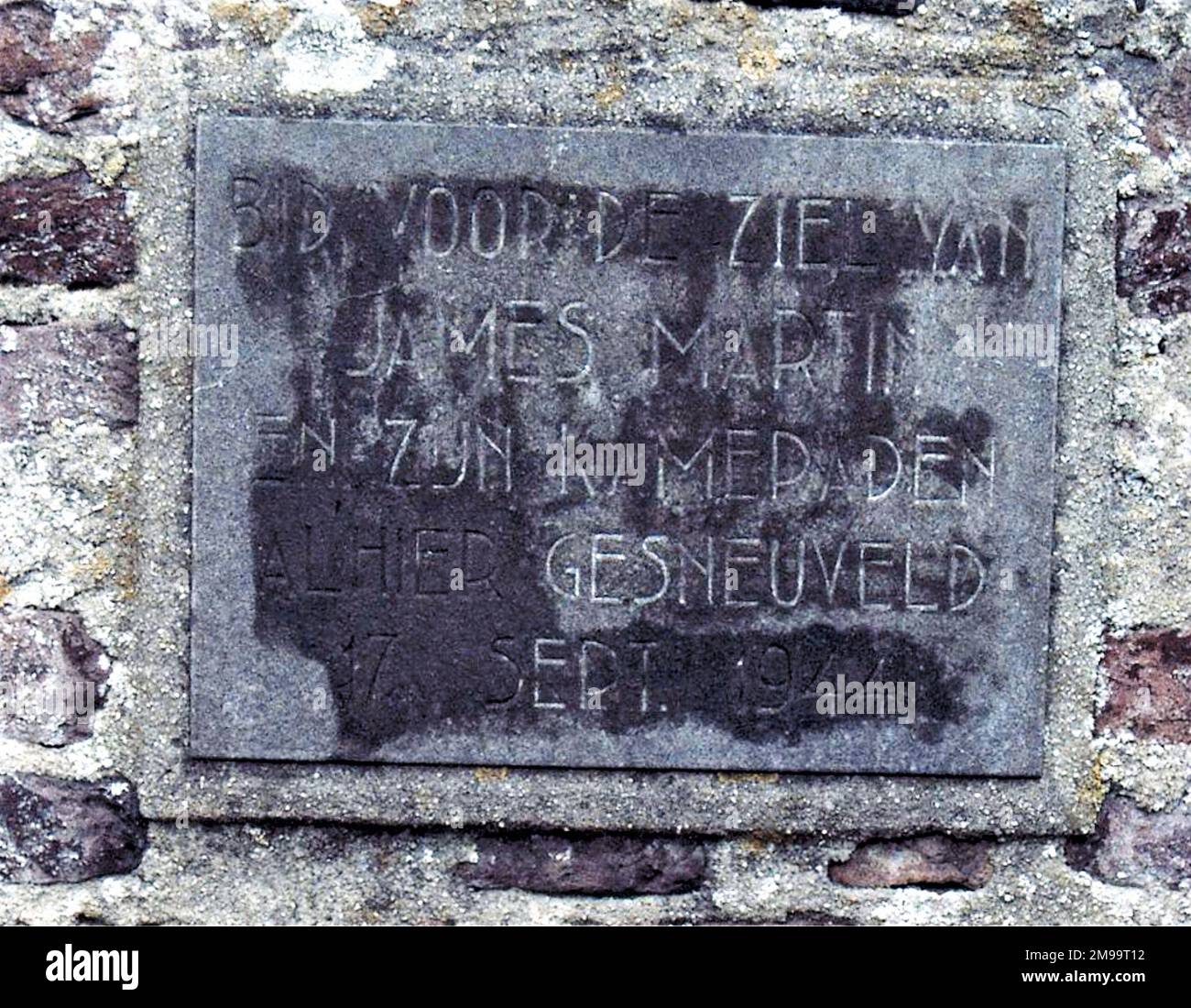 In der Mauer um die Kirche ist diese Tafel. Die Überschrift lautet: "Betet für die Seelen von James Martin und seinen Kameraden, die am 17. 1944. September hier gefallen sind." Niemand weiß, wer dieses rührende Denkmal errichtet hat. An diesem Tag wurde die Operation Market Garden eröffnet, in der zwölf Serien von C47 Skytrains Fallschirmjägern nach Greoesbeek transportierten. Einige der langsameren Flugzeuge wurden von Positionen auf dem Maas-Waal-Kanal und der Eisenbahnbrücke in der Nähe von Mook getroffen. Sie flogen alle weiter in Formation zu ihrer DZS. Eines der Flugzeuge wurde von James Martin geflogen. Trotzdem hat er es geschafft Stockfoto