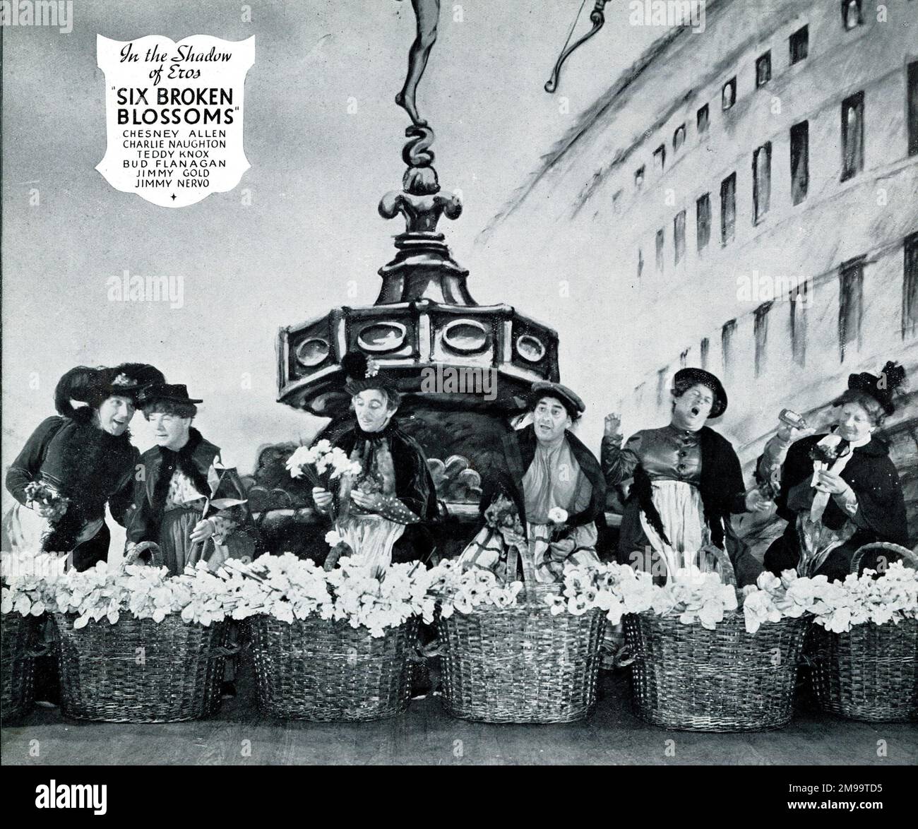 Die Crazy Gang verkleidete sich als Blumenverkäufer in „Six Broken Blossoms“ im Schatten von Eros (am Piccadilly Circus) im Londoner Rhapsody-Musical im London Palladium. Stockfoto