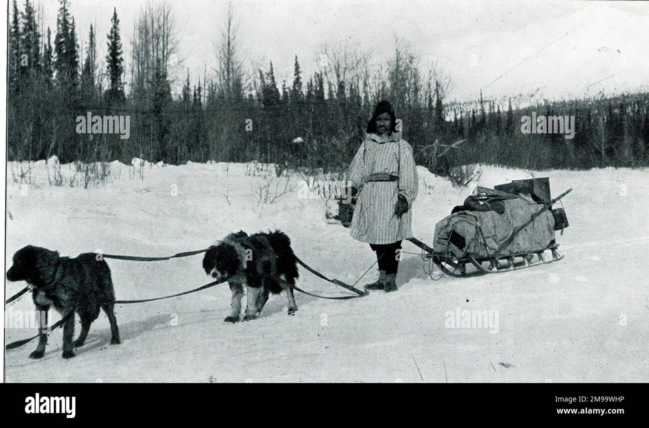 Indianischer Ureinwohner mit Hundeschlittenschlitten im Winter. Stockfoto