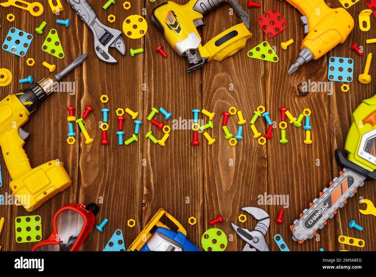 Farbenfrohe Spielzeugwerkzeuge mit Rahmen und Text Kinderzimmer auf Holzhintergrund Stockfoto