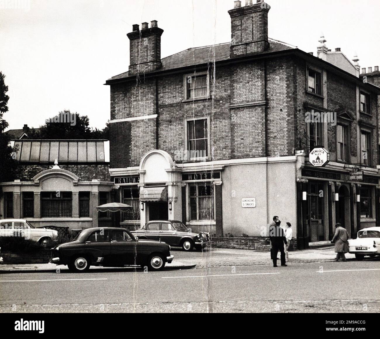 Foto: Railway Hotel, New Barnet, Greater London. Die Hauptseite des Aufdrucks (hier abgebildet) zeigt: Ecke auf der Ansicht des Pubs. Die Rückseite des Aufdrucks (auf Anfrage erhältlich) Details: Nichts für das Railway Hotel, New Barnet, Greater London EN4 8RR. Seit Juli 2018 . Das Hotel liegt in der Station Approach, New Barnet. Ein großes Hotel mit Portikett gegenüber dem Bahnhof, oft Auktionen von Immobilien und Kunstwerken. Es bestand von 1855 bis 1968, als es abgerissen wurde und durch einen Büroblock des GPO (jetzt BT) ersetzt wurde, der nun in Wohnungen umgewandelt wurde. Stockfoto