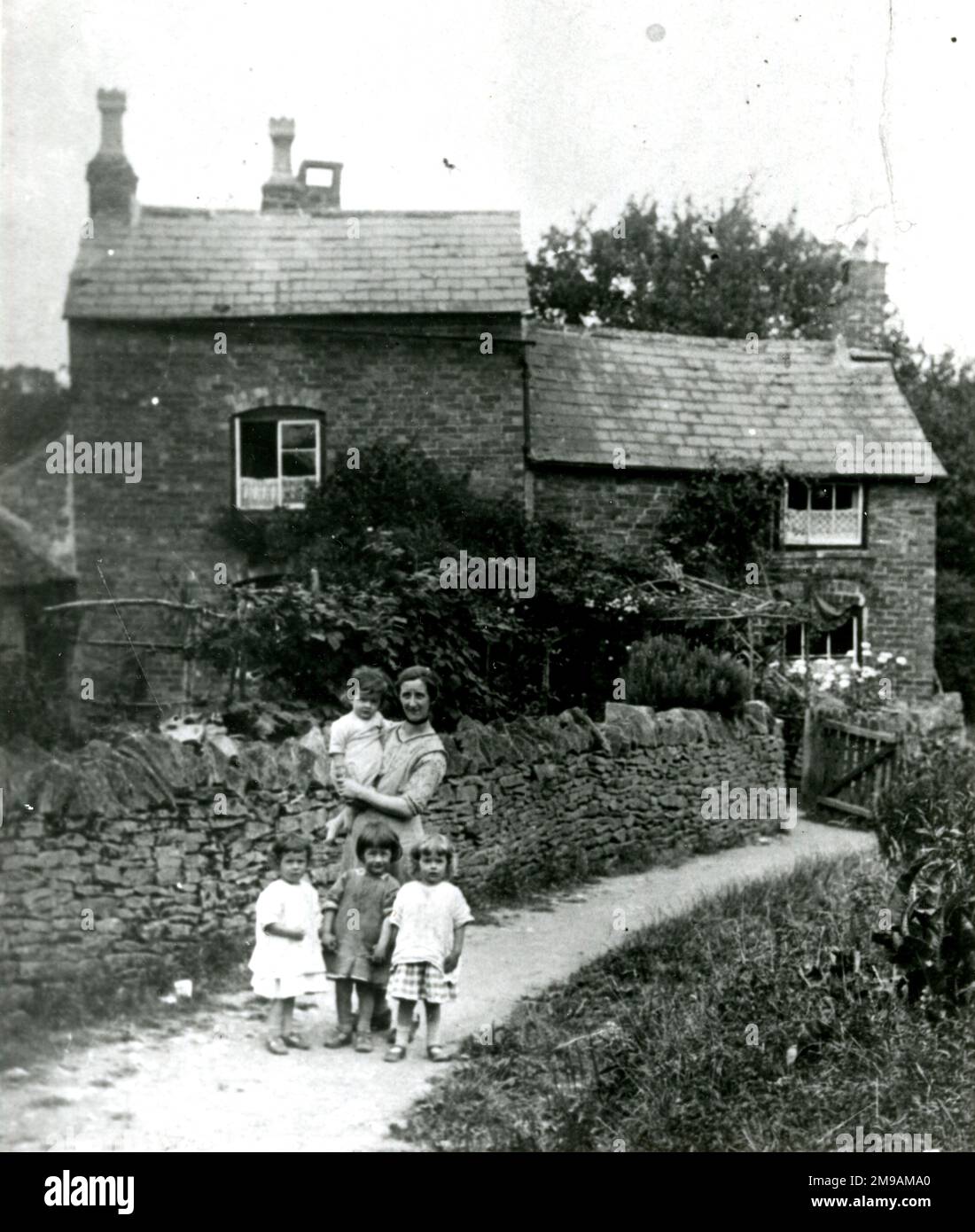 Draycott, das Dorf Cotswold, Frau Roper und ihre vier Kinder, die letzten Mieter des Brick House (in der Obstplantage nördlich von Farm Close). Das Haus wurde um 1863 erbaut und um 1949 abgerissen. Stockfoto