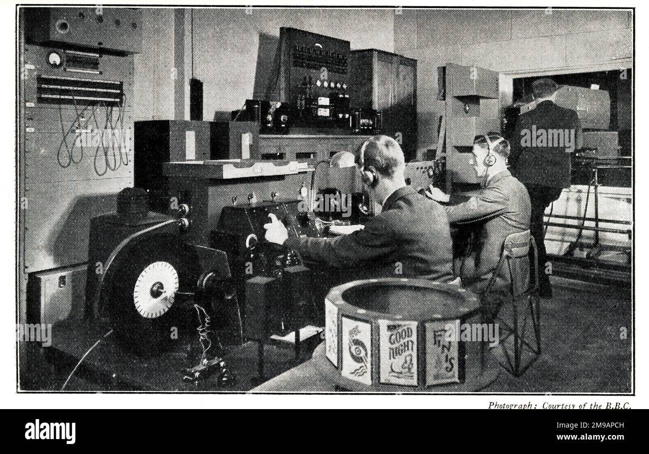 BBC Late Low Definition TV Control Room. Auf der rechten Seite befindet sich der Projektionsscanner für die Spiegeltrommel, auf der linken Seite befinden sich die beiden Kontrollempfänger. Die Ingenieure in Position (R bis L) sind Projektionisten, Bildverarbeitungsfunktionen, Ton- und Titelsteuerung. Das „Tuning in“-Design der BBC ist in der Sendertrommel (Bildunterschrift) im Vordergrund zu sehen. Stockfoto