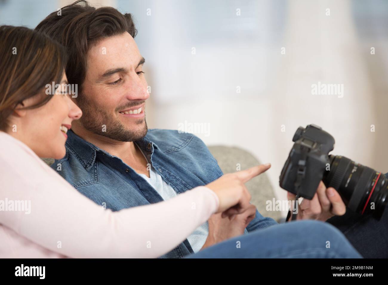 Mann und Frau, die sich Fotos auf ihrer dslr-Kamera ansehen Stockfoto