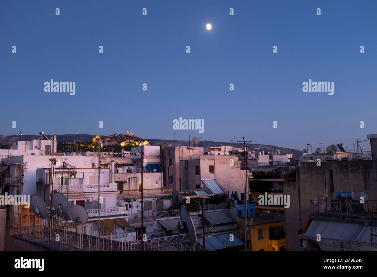 Der Mond erhebt sich über einem Viertel von Athen mit dem Lycabettus-Hügel im Hintergrund, Athen, Griechenland Stockfoto