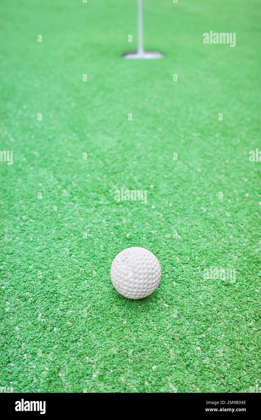 Nahaufnahme eines Golfballs auf einem Minigolfplatz, selektiver Fokus. Stockfoto