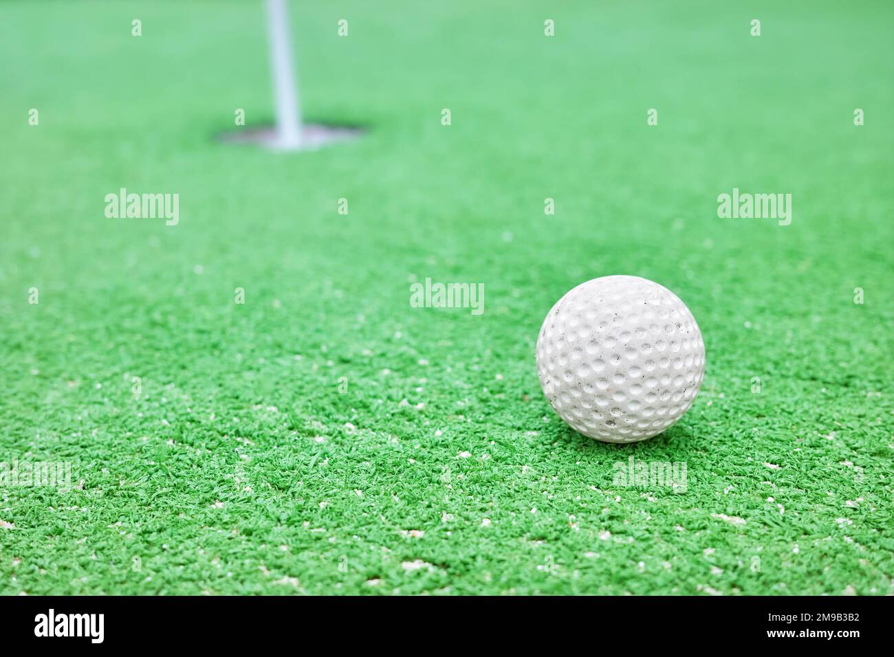 Nahaufnahme eines Golfballs auf einem Minigolfplatz, selektiver Fokus. Stockfoto