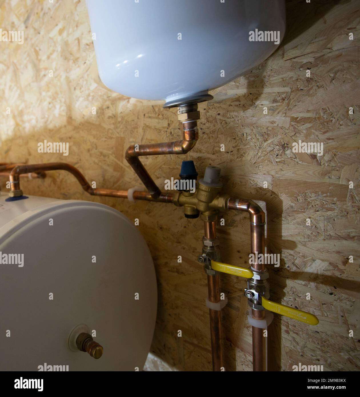 Sanitär-Warmwassertank mit Ausgleichbehälter an neu installierter Zentralheizung Stockfoto