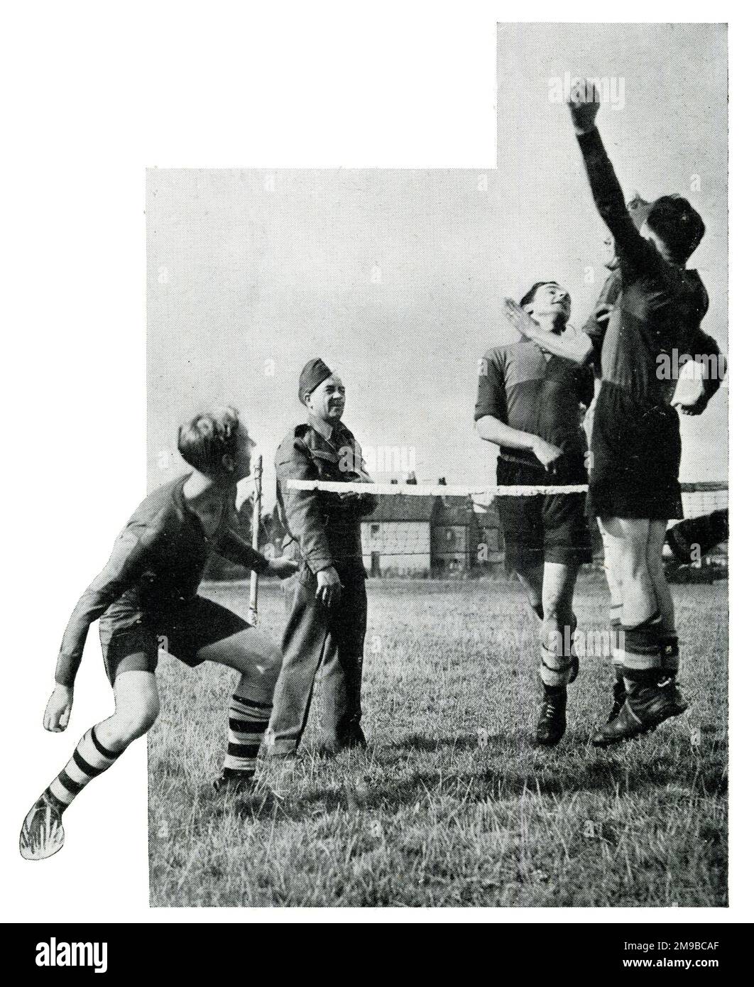 Alex James in Uniform sieht anderen Mitgliedern des Anti-Aircraft-Kommandos während des Zweiten Weltkriegs beim Fußballtennis zu Stockfoto