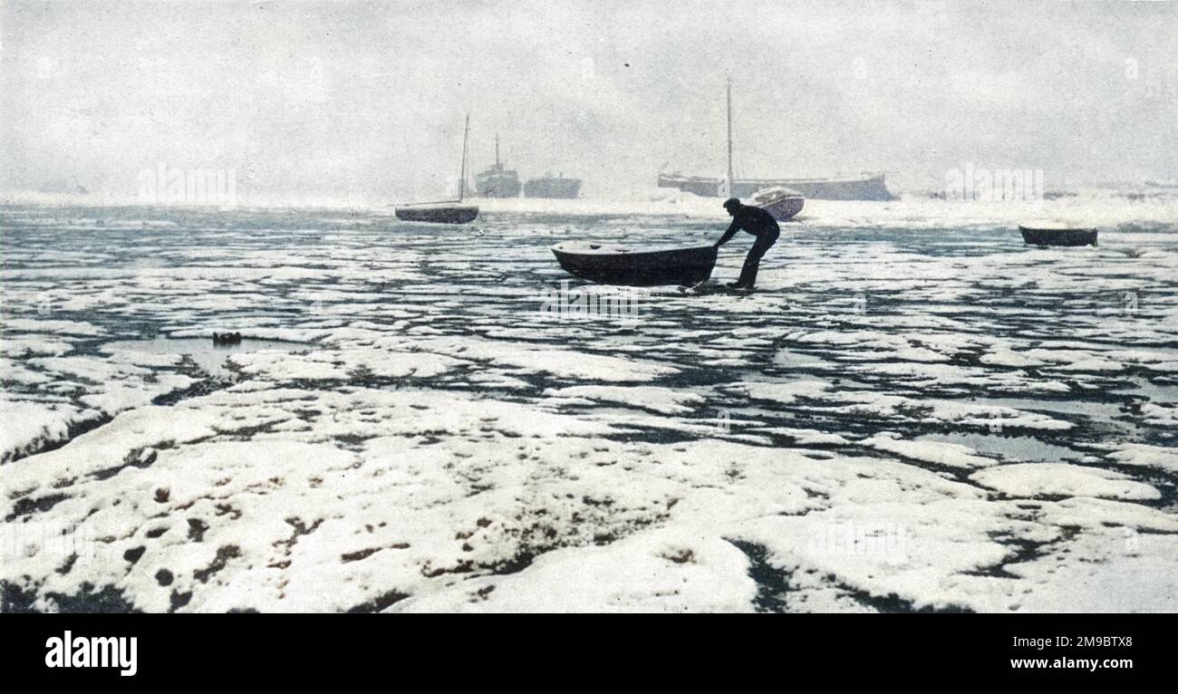 Eine Szene während des großen Gefrierens 1947, einem der härtesten Winter, den man in Großbritannien kennt. In Leigh-on-Sea in Essex wird ein Bootsmann vorgestellt, der sein Schlauchboot aus dem umschließenden Eis rettet, wodurch die Themse eher wie eine Polarlandschaft aussieht. Nur wenn die Bootsbesitzer alle vierundzwanzig Stunden ihr Schiff bewegen, können sie darauf hoffen, dass sie dem Eisdruck entkommen. Stockfoto